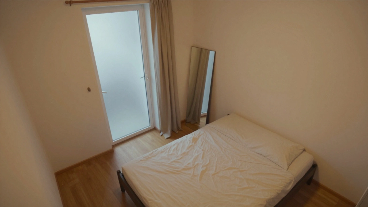 Вид сверху на спальню: кровать у двери, стеклянная дверь закрыта шторой, зеркало отражает её закрытое состояние.